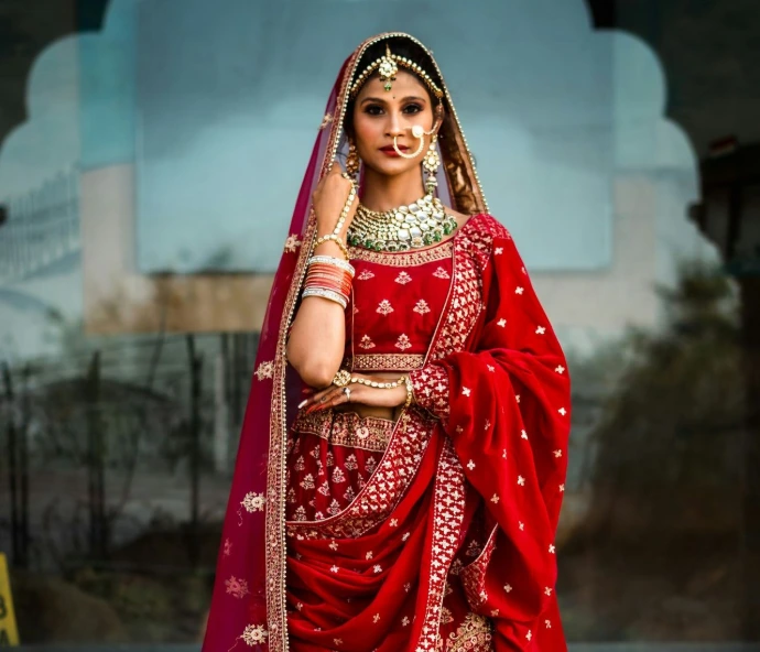a woman in a red and gold bridal outfit