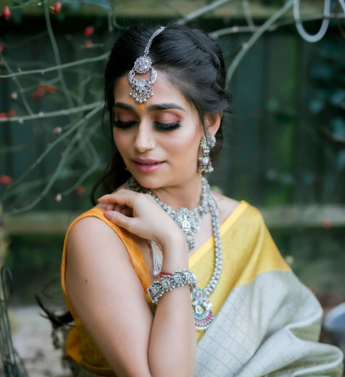 woman in yellow sleeveless dress wearing gold necklace